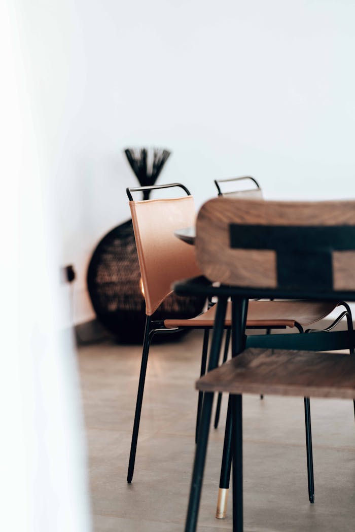 Elegant arrangement of wooden chairs in a minimalist indoor setting with subtle decoration.