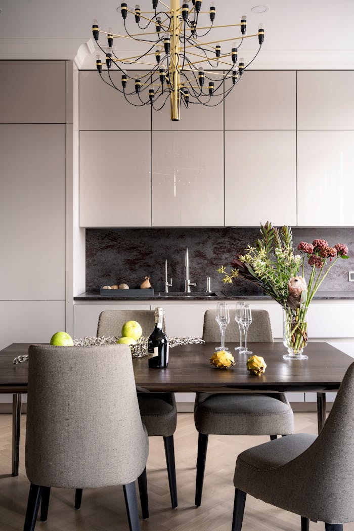 The Art of Drawing Readers In: Your attractive post title goes here Sophisticated dining space featuring modern chairs, a chandelier, and a floral arrangement.